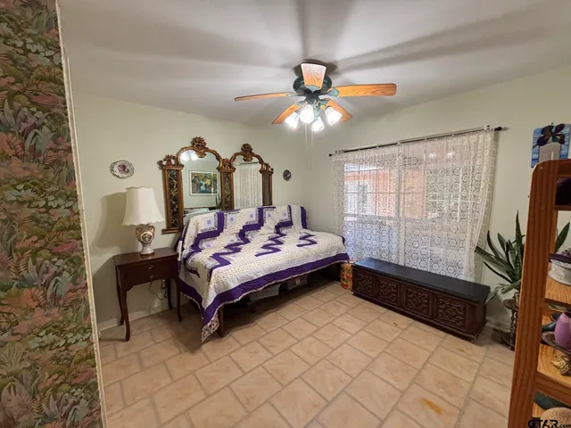 a spacious bedroom with a bed and a chandelier