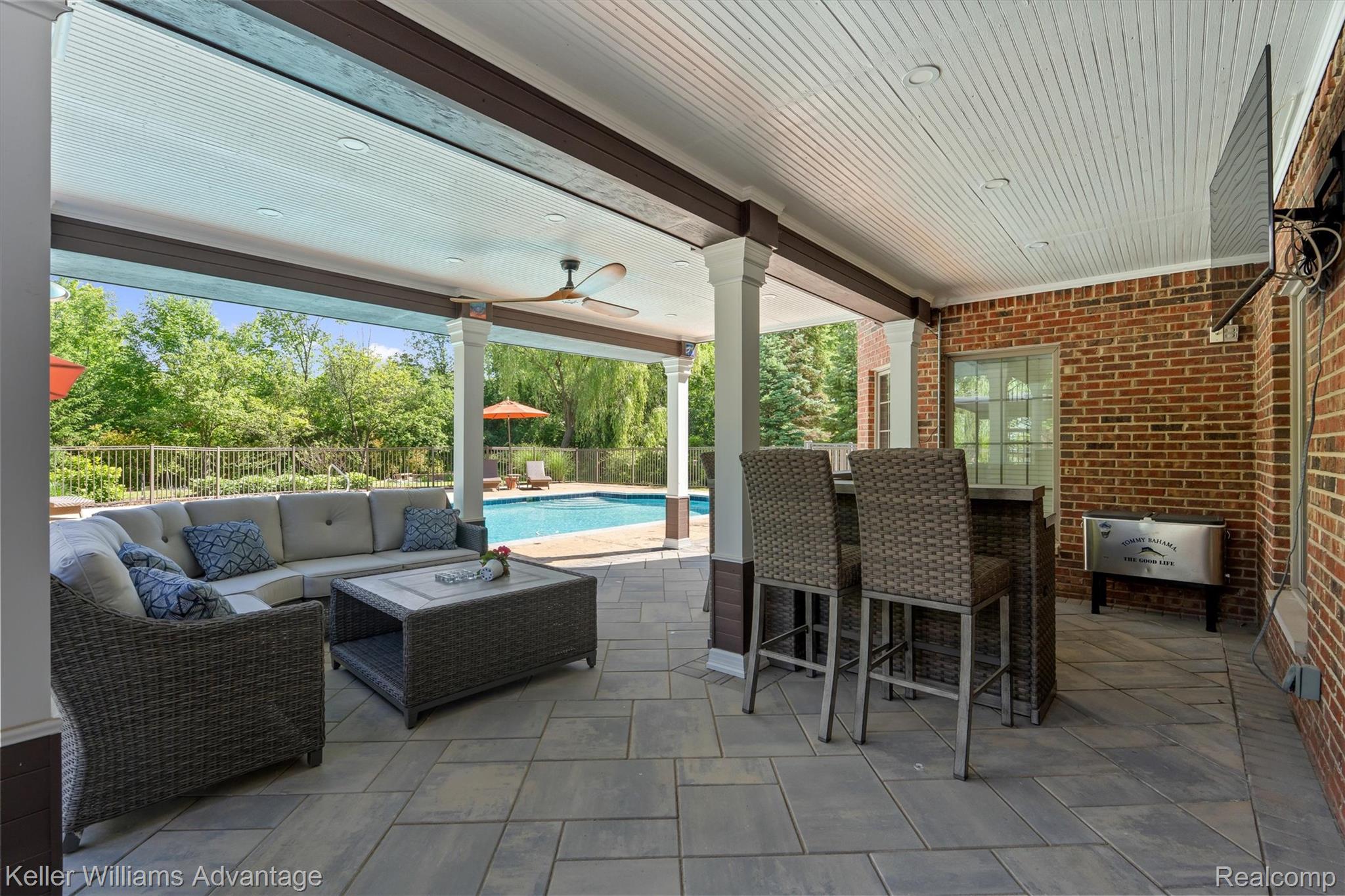 22878 Tree Top Court South Lyon, MI 48178 - Photo 52 of 75 Expansive covered patio featuring a paver stone surface and a beadboard ceiling