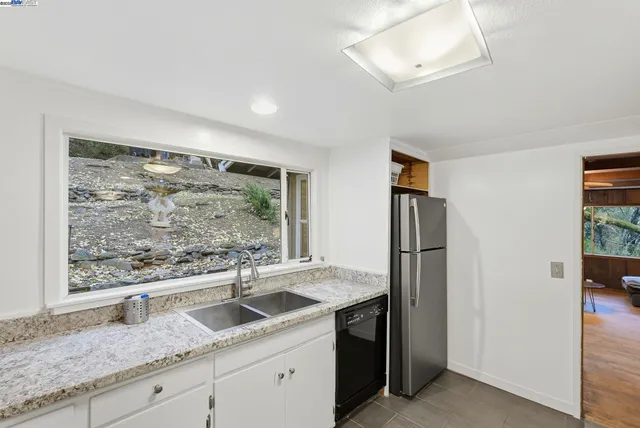 a kitchen with stainless steel appliances granite countertop a refrigerator and a sink