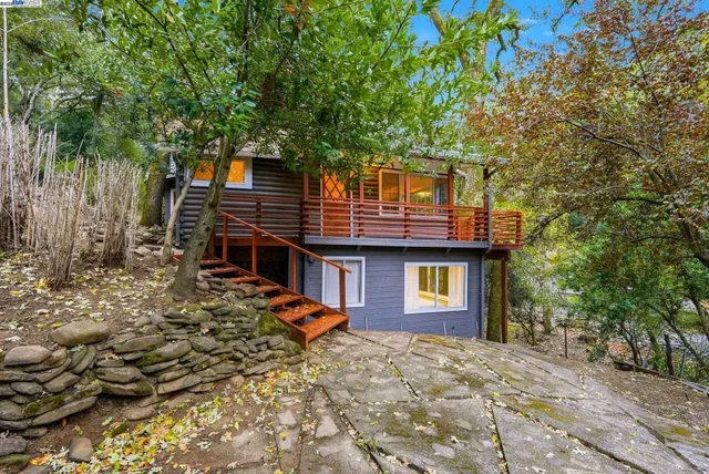 a front view of a house with a tree