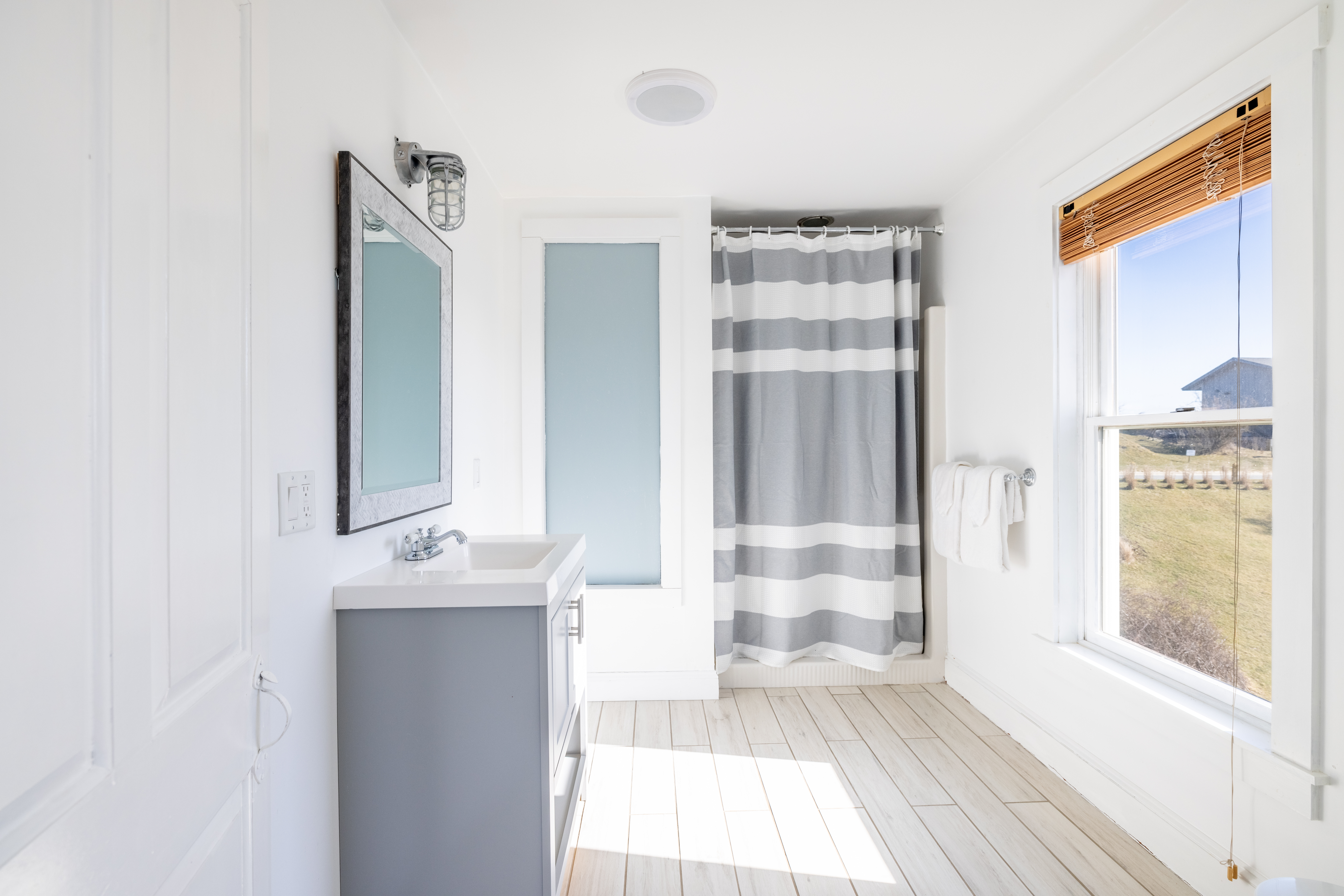 116 Baxter Road Nantucket, MA 02554 - Photo 15 of 28 a view of a bedroom with wooden floor and windows