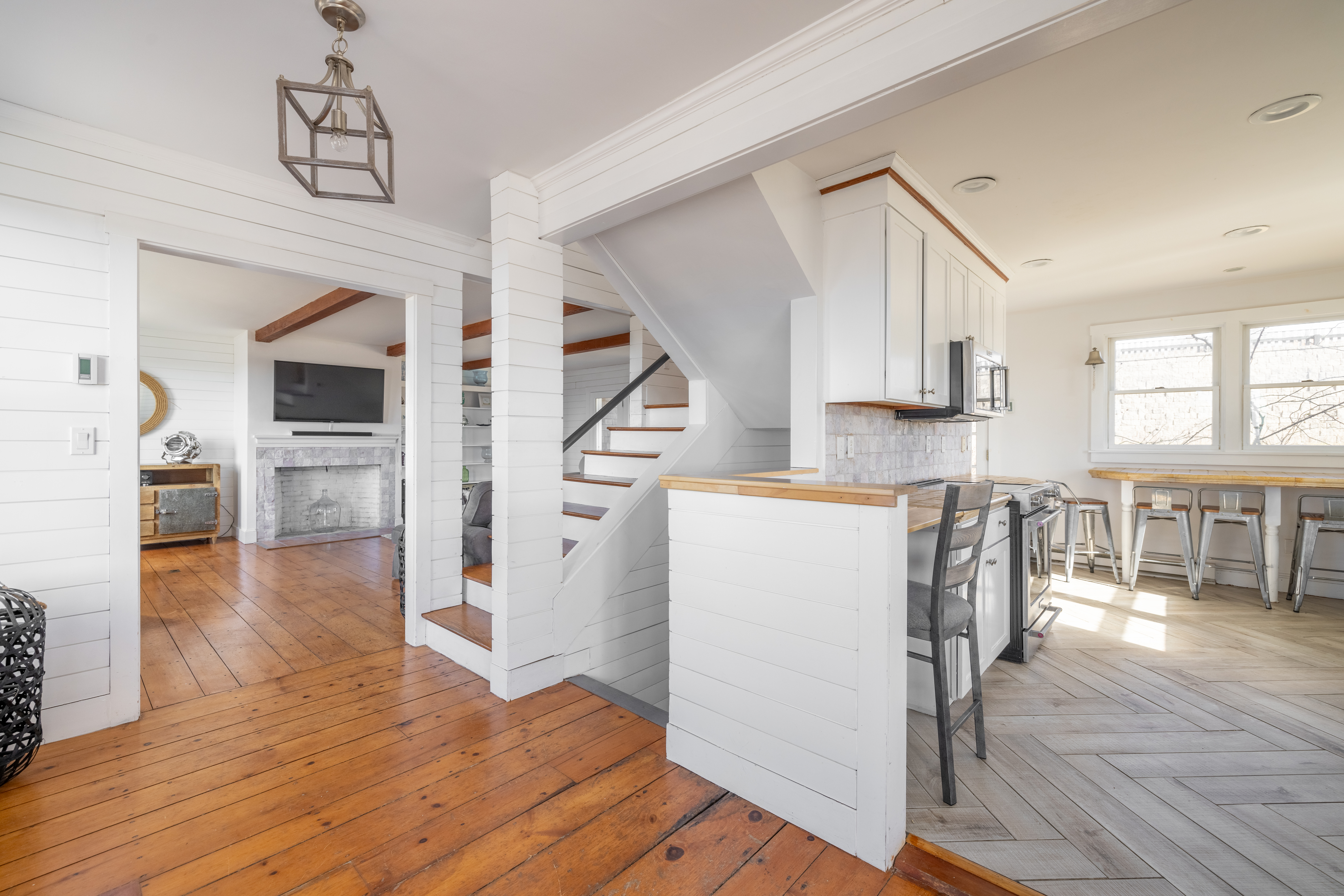 116 Baxter Road Nantucket, MA 02554 - Photo 9 of 28 a kitchen with wooden floors and white cabinets