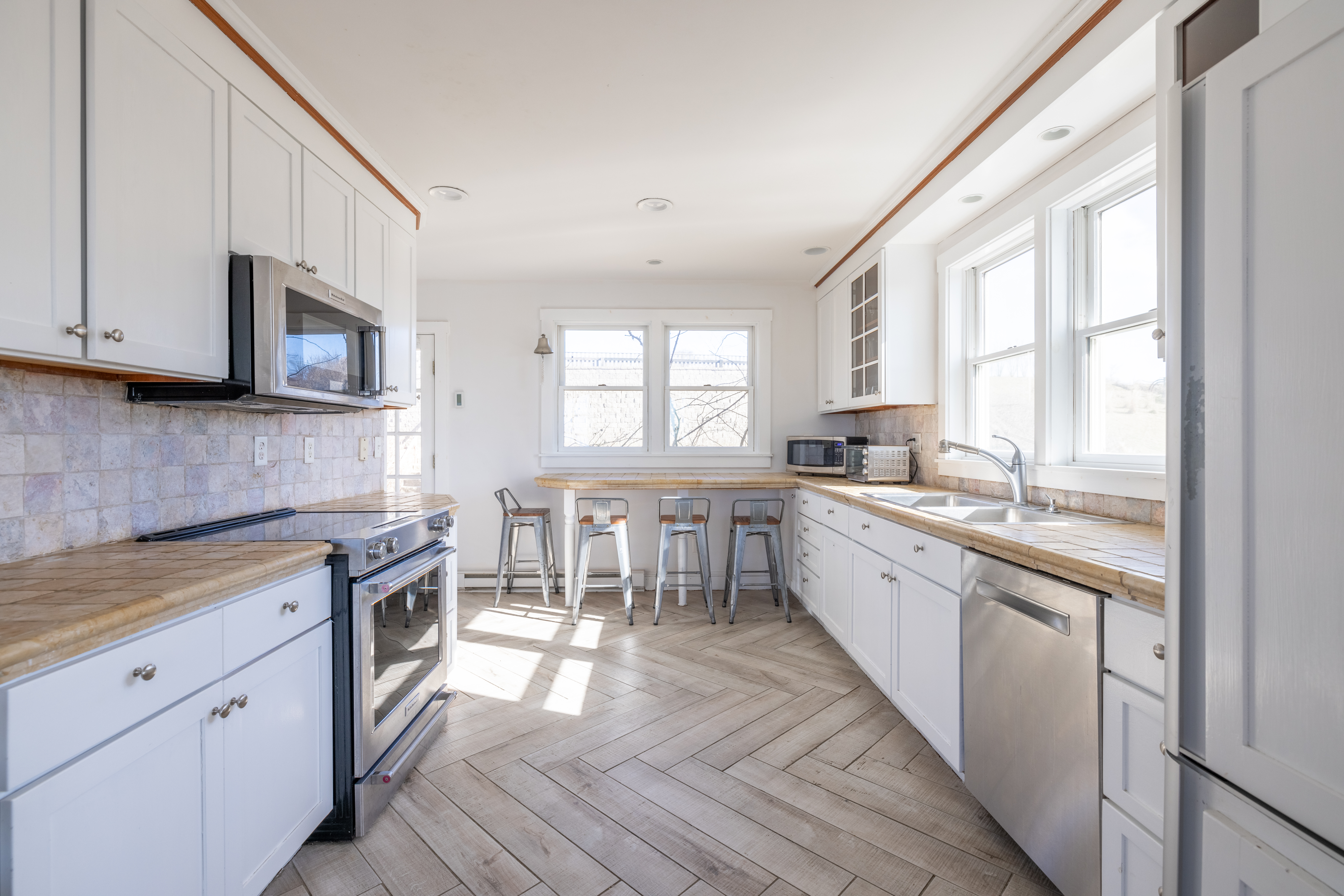 116 Baxter Road Nantucket, MA 02554 - Photo 10 of 28 a kitchen with stainless steel appliances granite countertop a stove a sink and a microwave