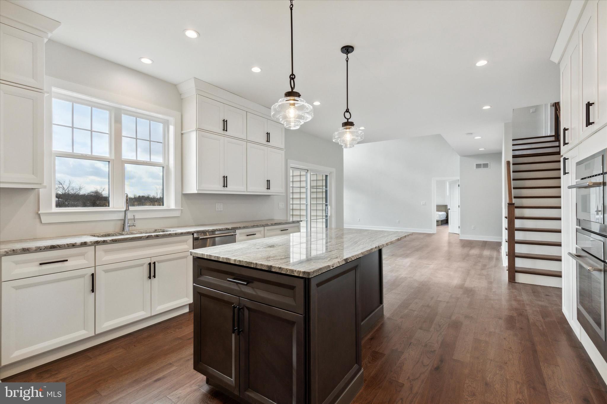 124 Schultz Road Sellersville, PA 18960 - Photo 16 of 29 a kitchen with a stove center island wooden floor cabinets and a chandelier