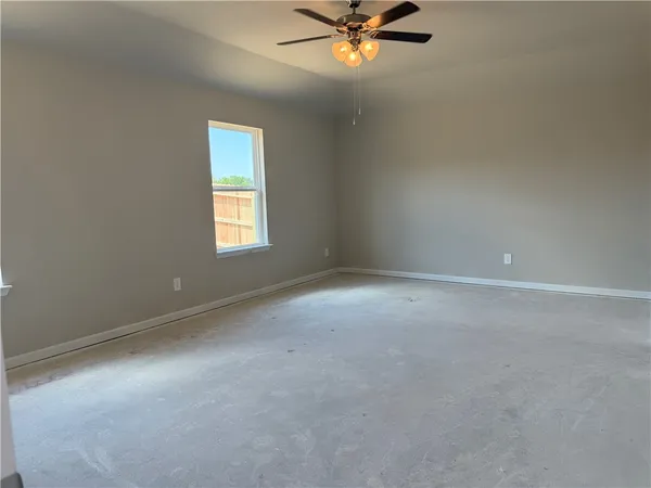 a view of a big room with windows and chandelier fan