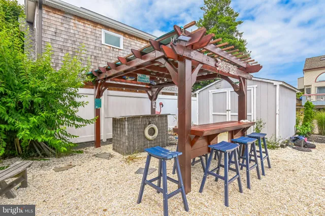 a patio with table and chairs with potted plants