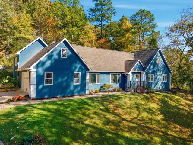 a view of a yard in front of a house with large tree