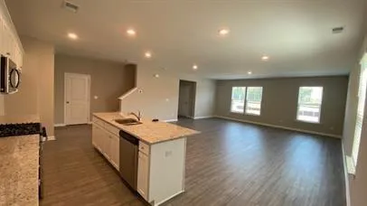 a kitchen with a stove and a wooden floor