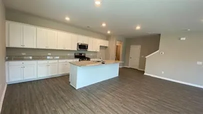 a kitchen with cabinets and wooden floor