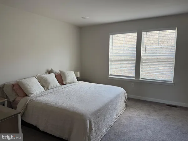 a bed sitting in a bedroom next to a window