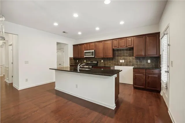 a kitchen with stainless steel appliances granite countertop a refrigerator sink and stove