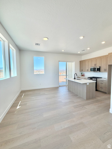 915 West Gold Ridge Ln Street St. George, UT 84790 - Photo 4 of 30 Open-concept living space featuring wood-finish flooring, recessed lighting, and ample natural light from multiple windows and a sliding glass door