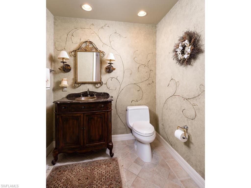 295 Grande Way, Unit 401 Naples, FL 34110 - Photo 11 of 19 a bathroom with a toilet a sink and mirror