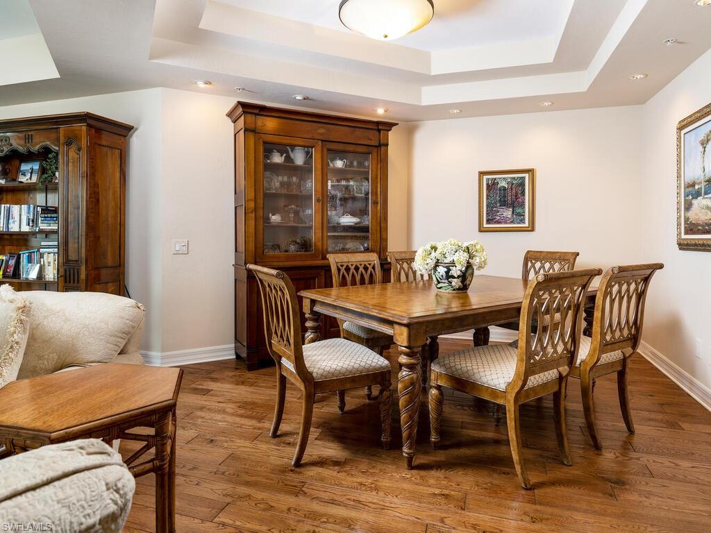 295 Grande Way, Unit 401 Naples, FL 34110 - Photo 2 of 19 a view of a dining room with furniture window and wooden floor