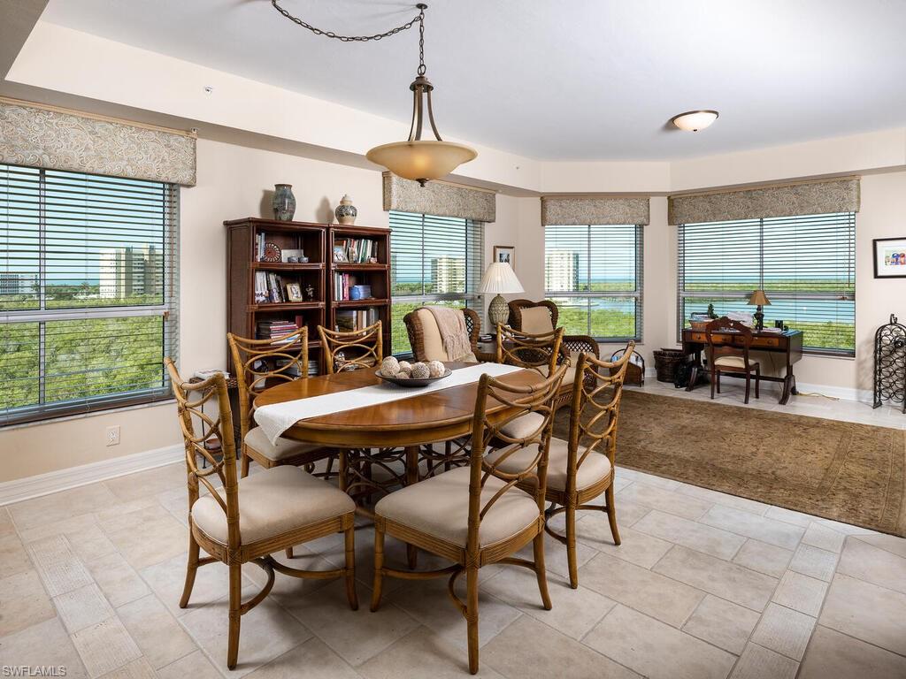 295 Grande Way, Unit 401 Naples, FL 34110 - Photo 4 of 19 a dining room with furniture a chandelier and window