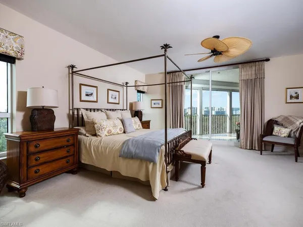 a spacious bedroom with a bed and a chandelier