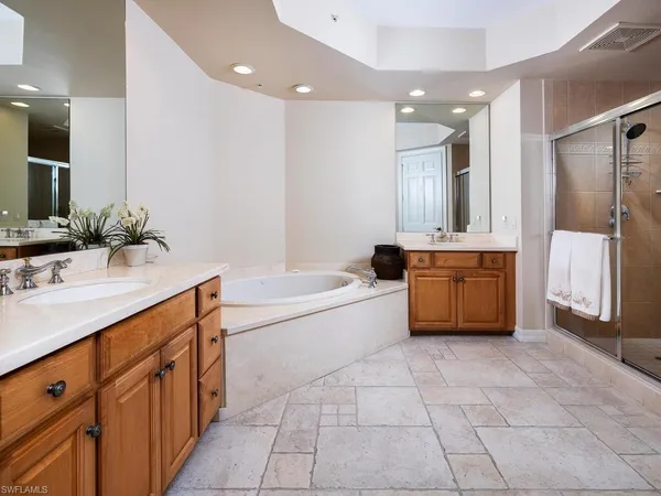a spacious bathroom with a tub sink and a mirror