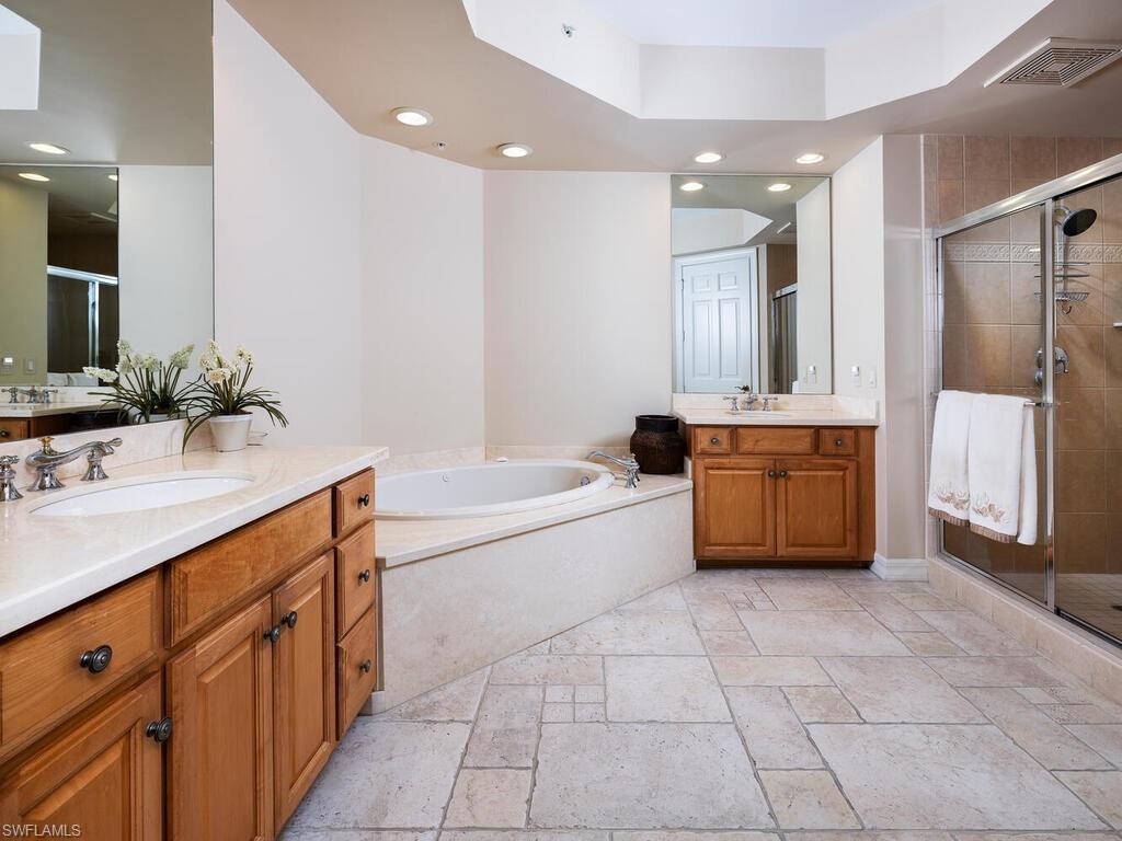 295 Grande Way, Unit 401 Naples, FL 34110 - Photo 6 of 19 a spacious bathroom with a tub sink and a mirror