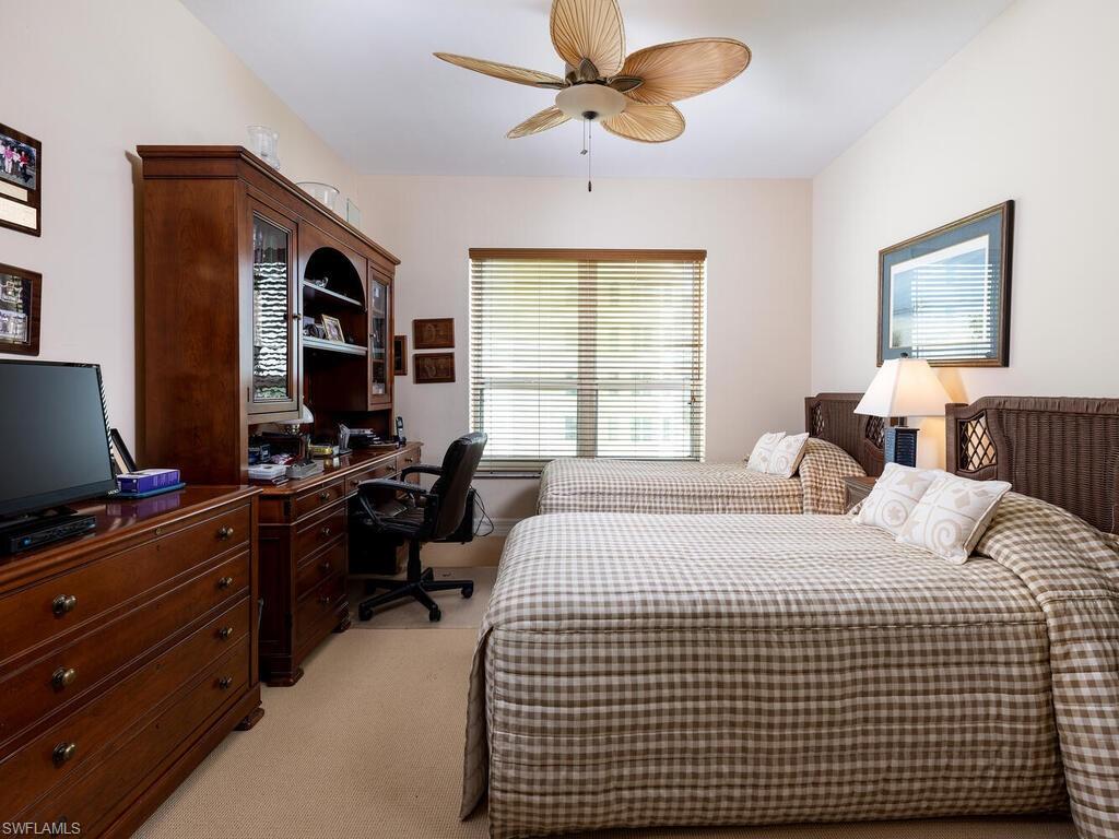295 Grande Way, Unit 401 Naples, FL 34110 - Photo 7 of 19 a bedroom with a bed and a desk