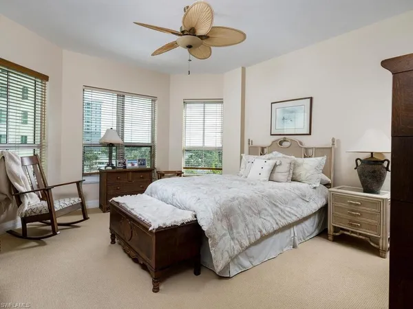 a spacious bedroom with a bed a couch and large windows