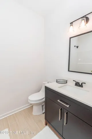 a bathroom with a granite countertop toilet sink and mirror
