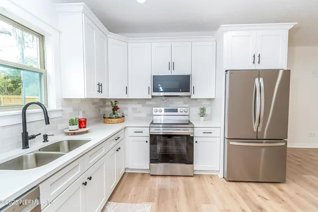 a kitchen with stainless steel appliances a refrigerator stove and sink