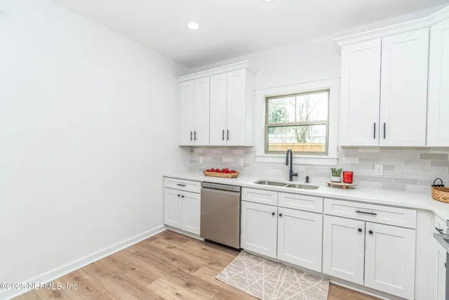 a kitchen with cabinets a sink dishwasher window and cabinets