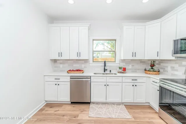 a kitchen with stainless steel appliances granite countertop a sink and cabinets