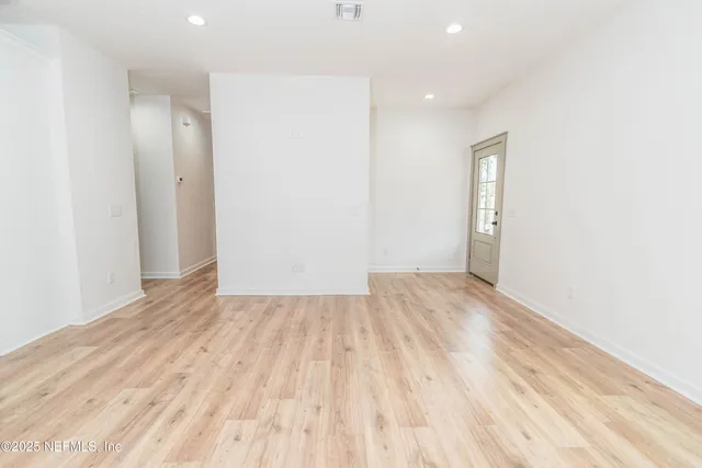 a view of empty room with wooden floor