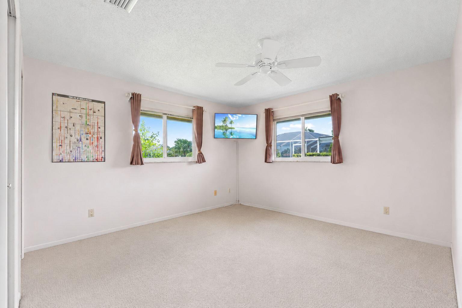 3374 Southeast Fairway East Stuart, FL 34997 - Photo 26 of 65 an empty room with windows and fan