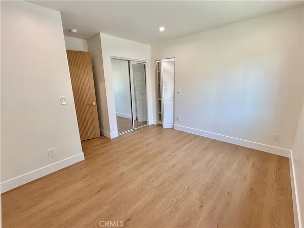 an empty room with wooden floor and entrance