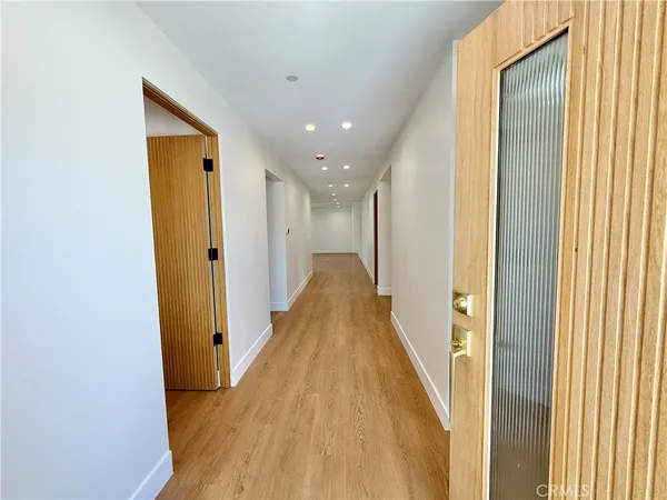 a view of a hallway with wooden floor and staircase