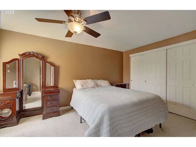 a bedroom with a bed mirror and a window