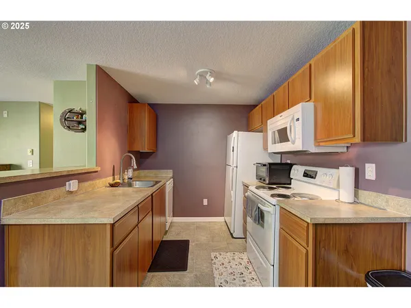 a kitchen that has a sink a stove counter top space and cabinets