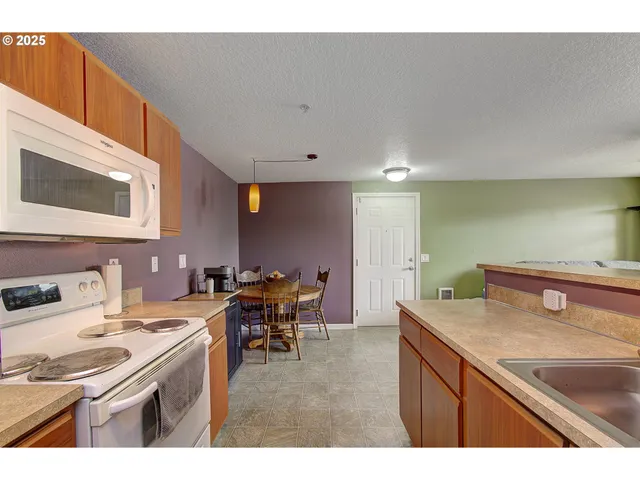 a kitchen with a sink a stove and chairs