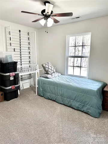 a bedroom with a bed a couch and a window