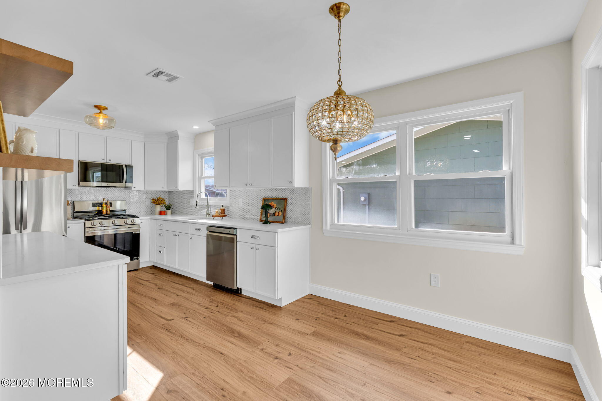 69 Clay Circle Brick, NJ 08724 - Photo 14 of 27 a kitchen with stove a refrigerator and white cabinets with wooden floors