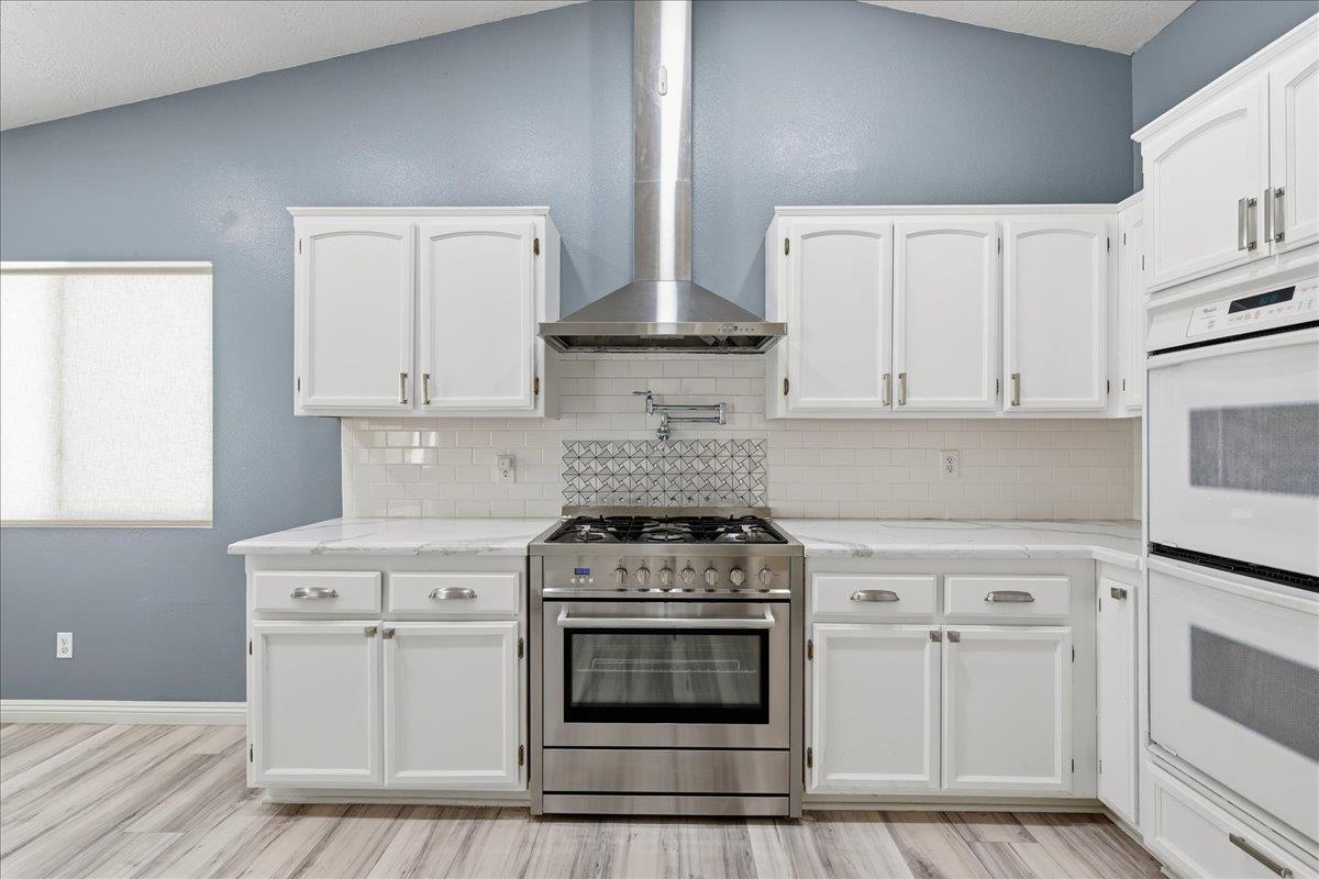 15358 Lookout Road Apple Valley, CA 92307 - Photo 15 of 30 a kitchen with white cabinets and appliances