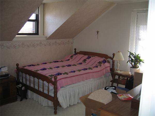 26 Wintworth Street Chicopee, MA 01013 - Photo 9 of 13 a bed sitting in a bedroom next to a window