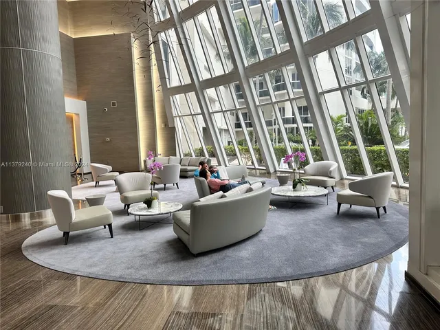 a living room with furniture and large windows