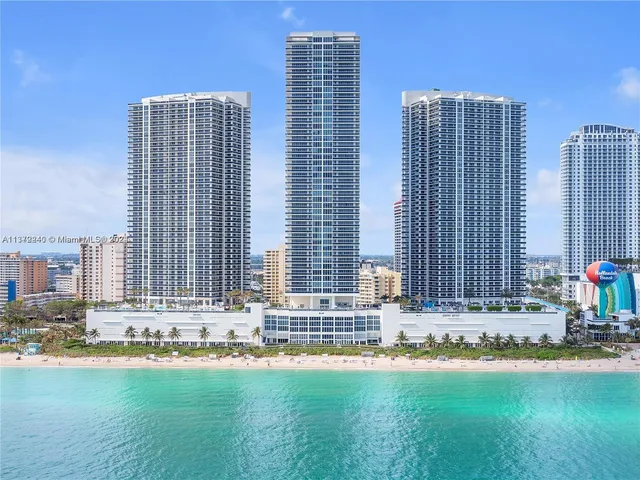 a front view of a building with a yard and a garage