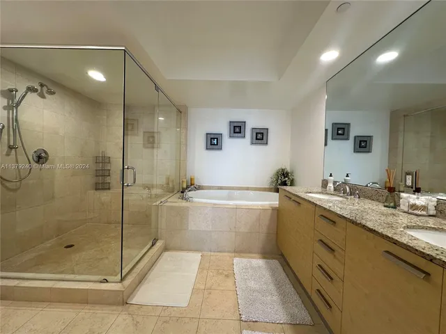 a bathroom with a tub sink shower and mirror