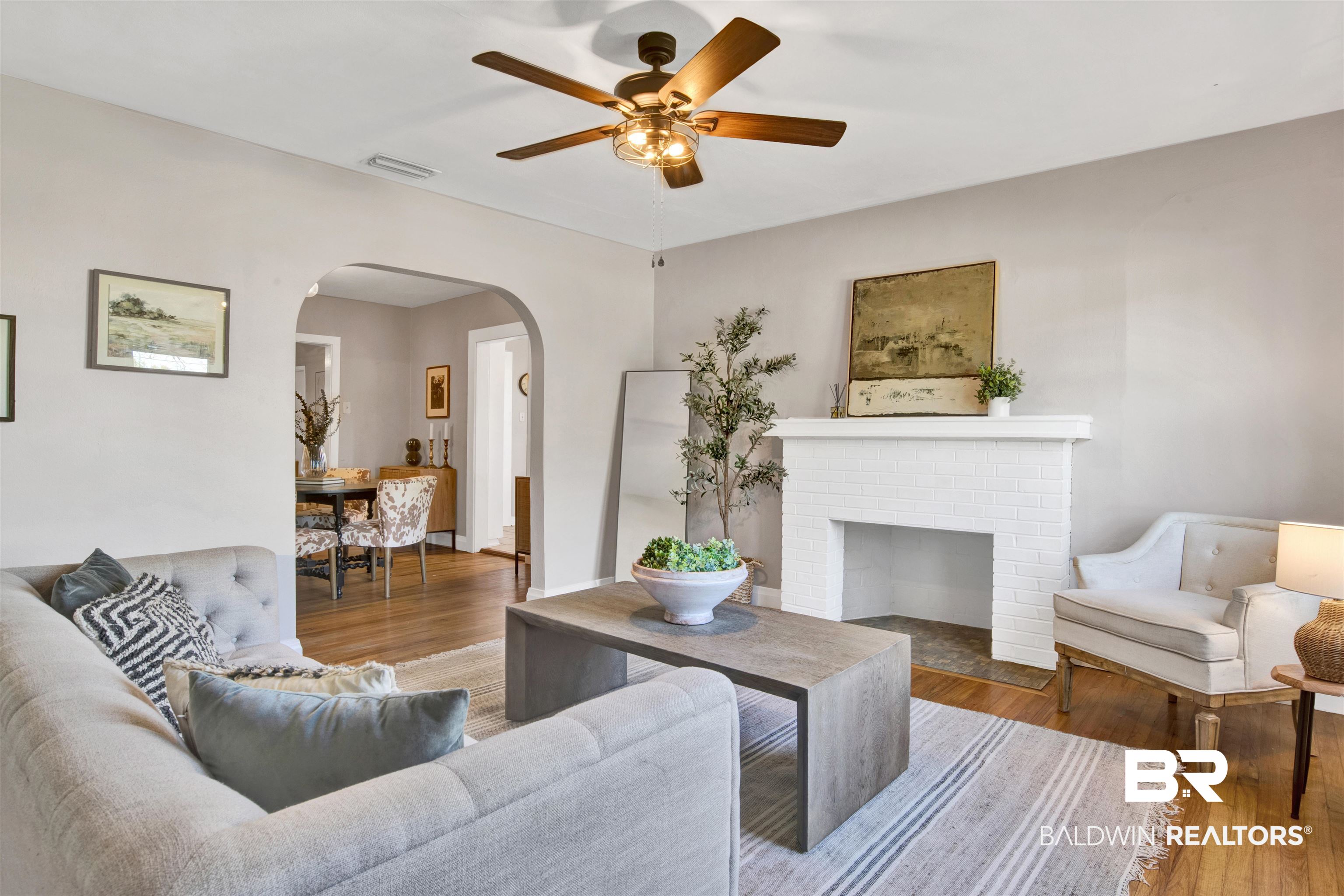 160 Emogene Place Mobile, AL 36606 - Photo 4 of 32 Living area featuring wood finished floors, a ceiling fan, and a fireplace