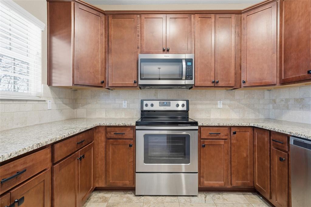 37 Buckskin Loop Belton, TX 76513 - Photo 11 of 25 a kitchen with granite countertop wooden cabinets and stainless steel appliances