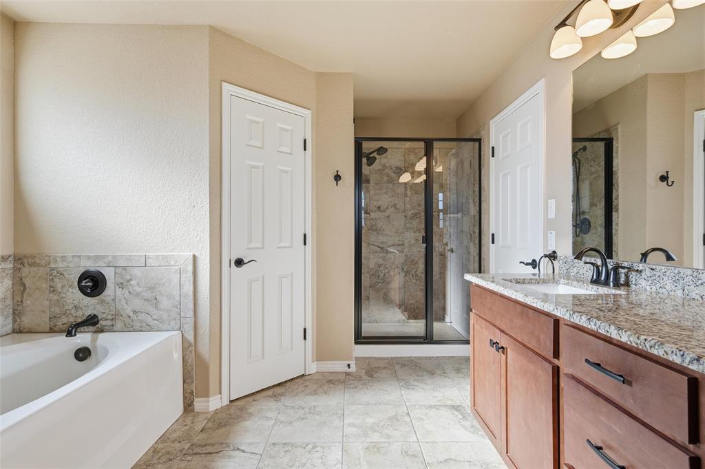 37 Buckskin Loop Belton, TX 76513 - Photo 17 of 25 a bathroom with a granite countertop sink a mirror a bathtub and shower