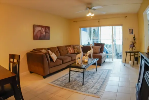 a living room with couches and a dining table with wooden floor
