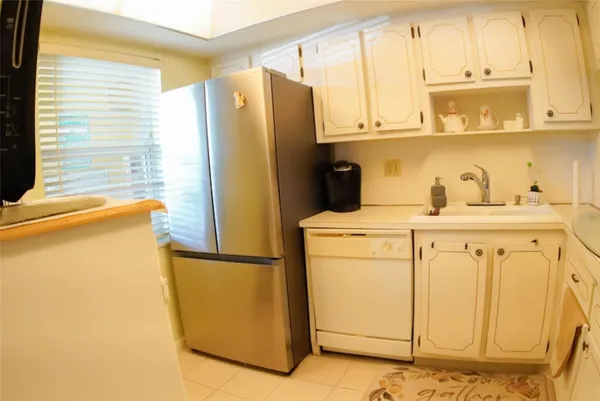 a bathroom with a refrigerator and a window