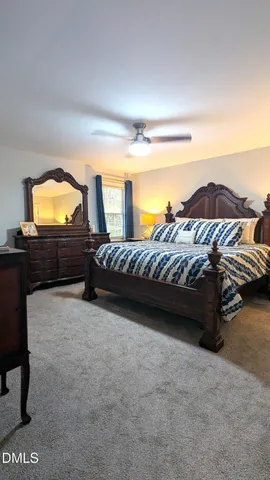 a bedroom with a bed and a flat tv screen on dresser