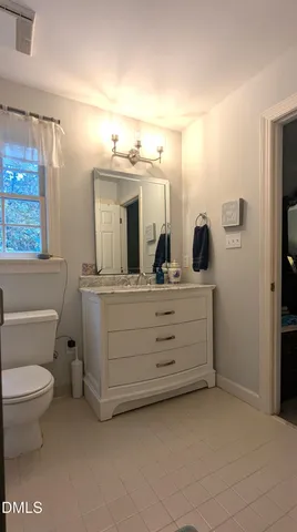 a bathroom with a double vanity sink toilet and mirror
