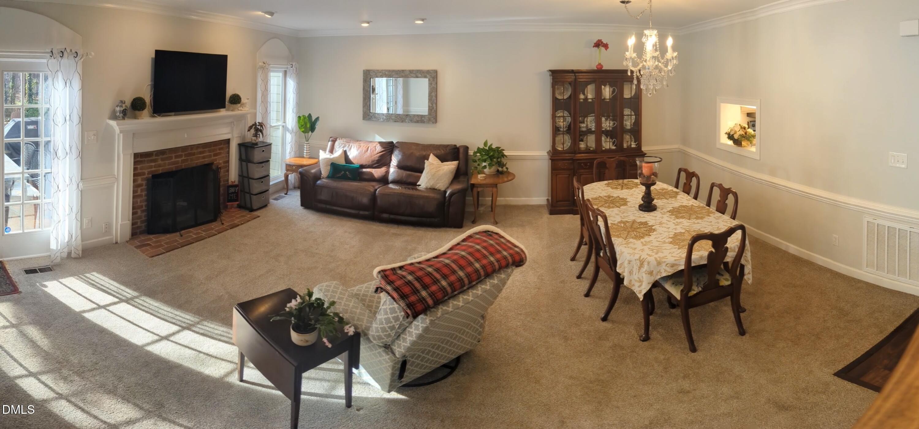 540 Weathergreen Drive Raleigh, NC 27615 - Photo 9 of 20 a living room with furniture a fireplace and a flat screen tv